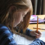Homework - Girl Drawing On Brown Wooden Table