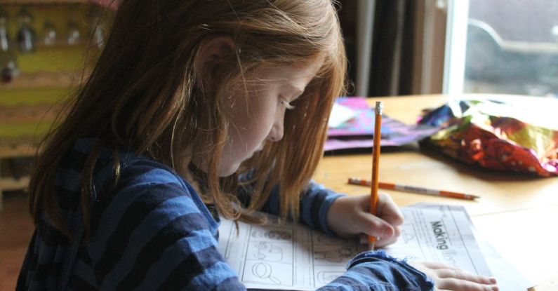 Homework - Girl Drawing On Brown Wooden Table