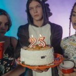 Birthday Party - Women Holding Disposable Cups Beside a Man Holding a Birthday Cake